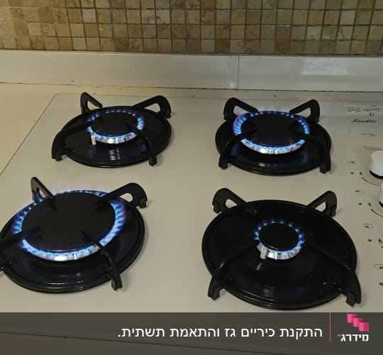 כיריים גז עם ארבעה מבערים דולקים במטבח